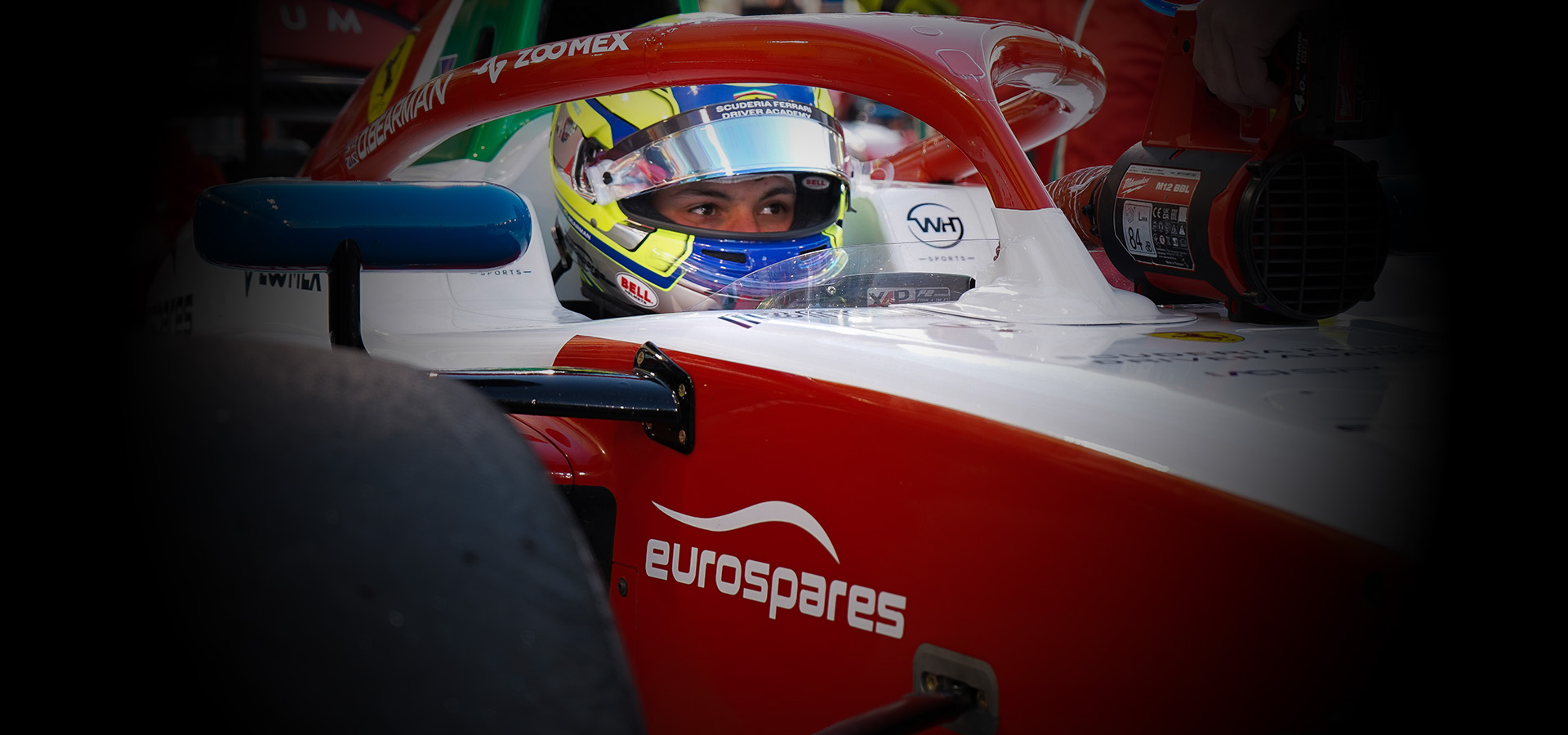 Oliver Bearman assis dans sa voiture de course de Formule 2 qui porte le logo Eurospares sur le côté. 