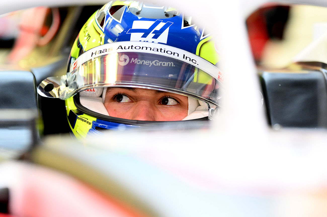 2025 Ollie Bearman sitting in his MoneyGram Haas F1 Car wearing his helmet featuring the Eurospares sponsor logo.
