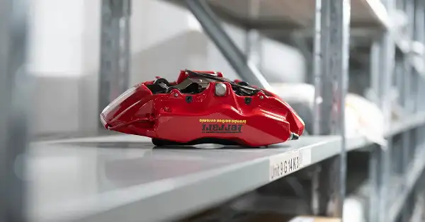 Étrier de frein Brembo rouge Ferrari sur une étagère de stockage dans l'entrepôt d'Eurospares.